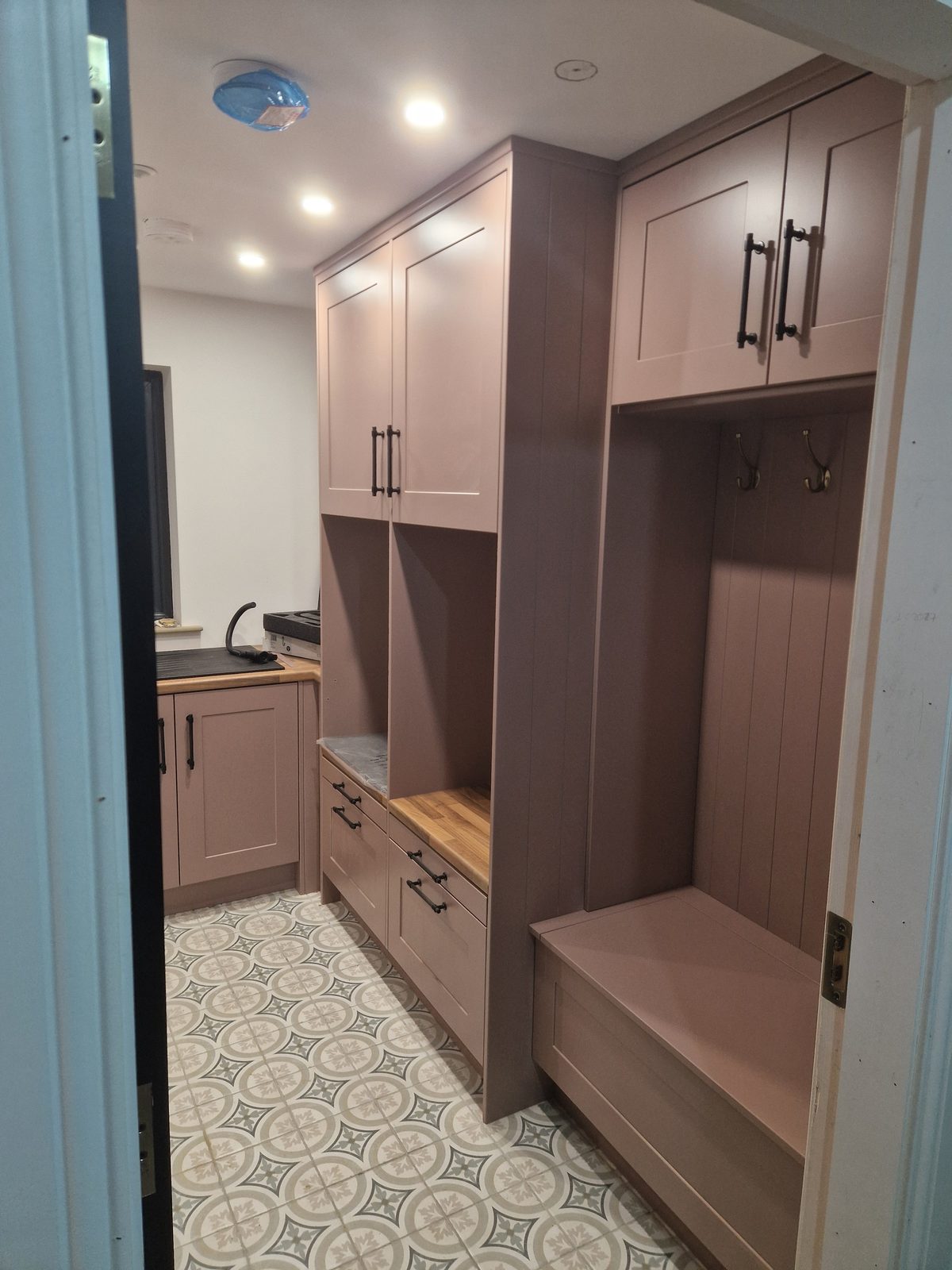 Boot room and utility in soft mauve with bench and patterned floor