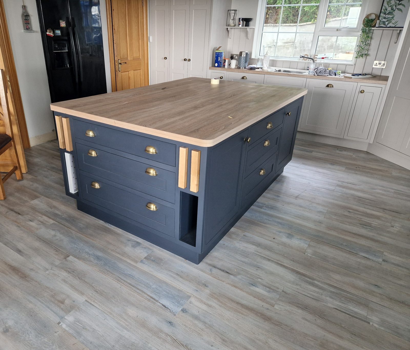 Navy painted kitchen island with solid timber top and brass cup handles