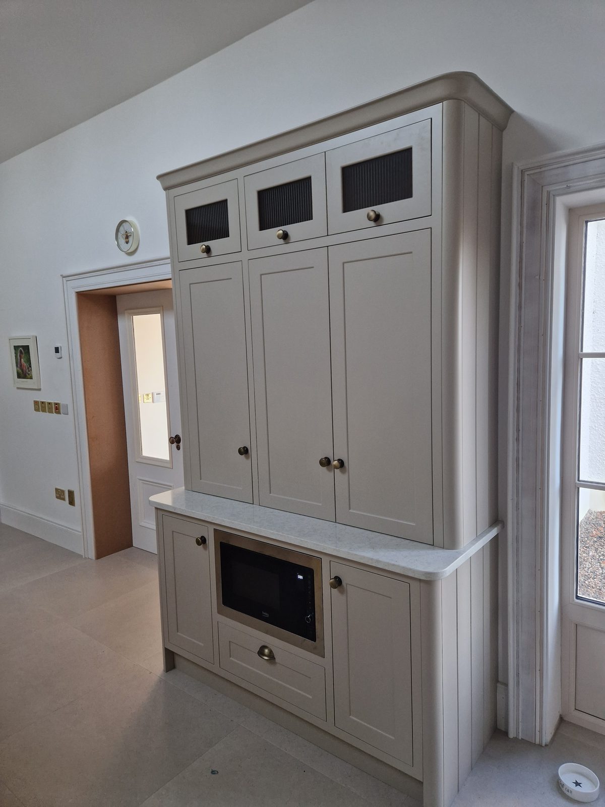 Bespoke cream larder dresser with glazed cabinets and integrated microwave